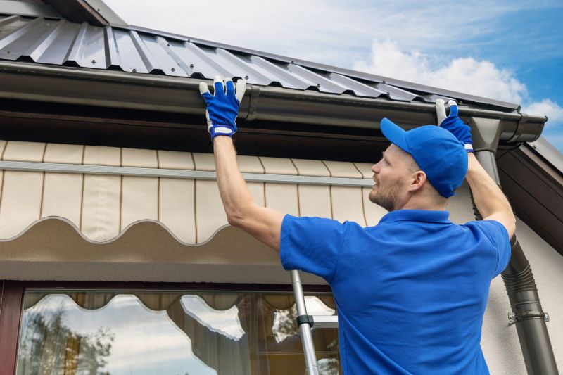 Worker attaching gutters to a roof